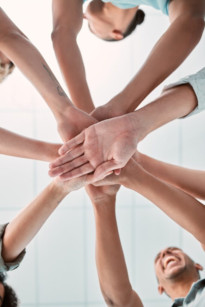 Hands, collaboration and unity with a business team in a huddle or circle in the office together fr